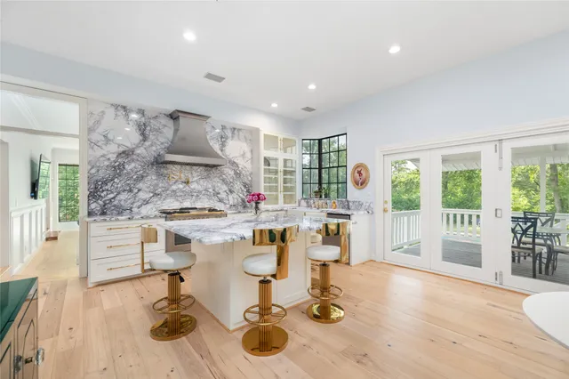 a kitchen with a table chairs stove and white cabinets