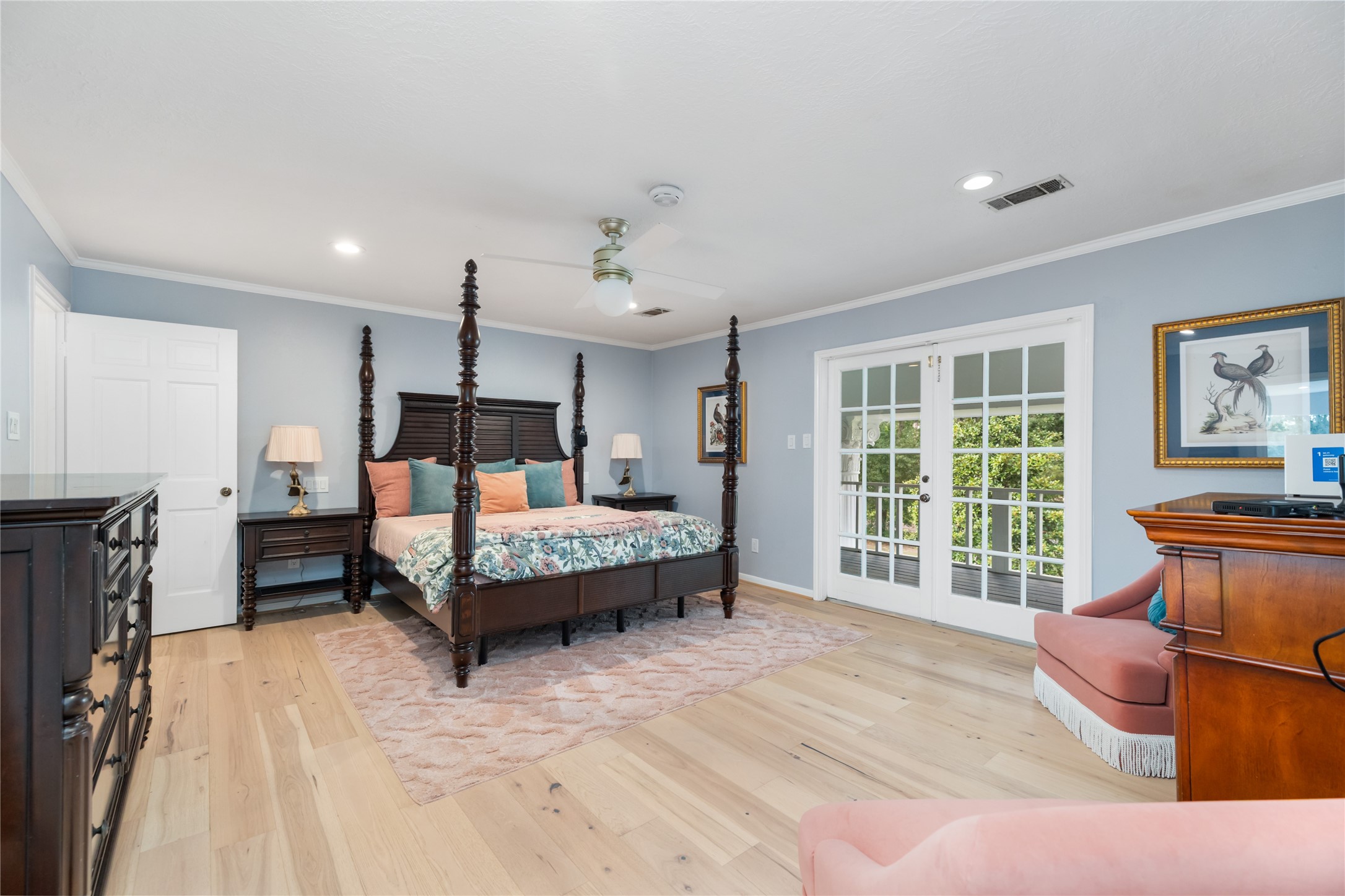 17003 Creeksouth Road Houston, TX 77068 - Photo 26 of 49 This massive primary suite exudes refined elegance with crown molding and a cozy sitting area. French doors provide a private entrance to the covered balcony, creating a serene retreat where indoor comfort meets outdoor tranquility.