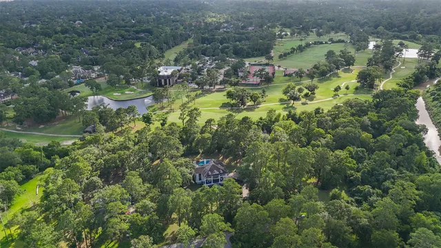 an aerial view of residential house with outdoor space and trees all around
