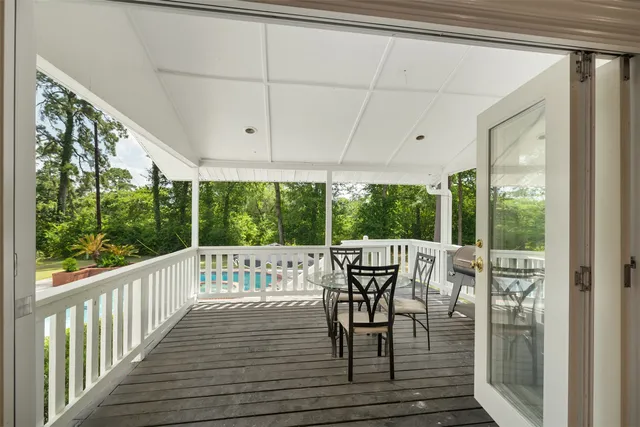 a view of a chairs and table in patio with wooden floor