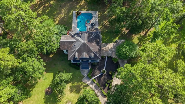 an aerial view of a house with swimming pool a yard and stairs