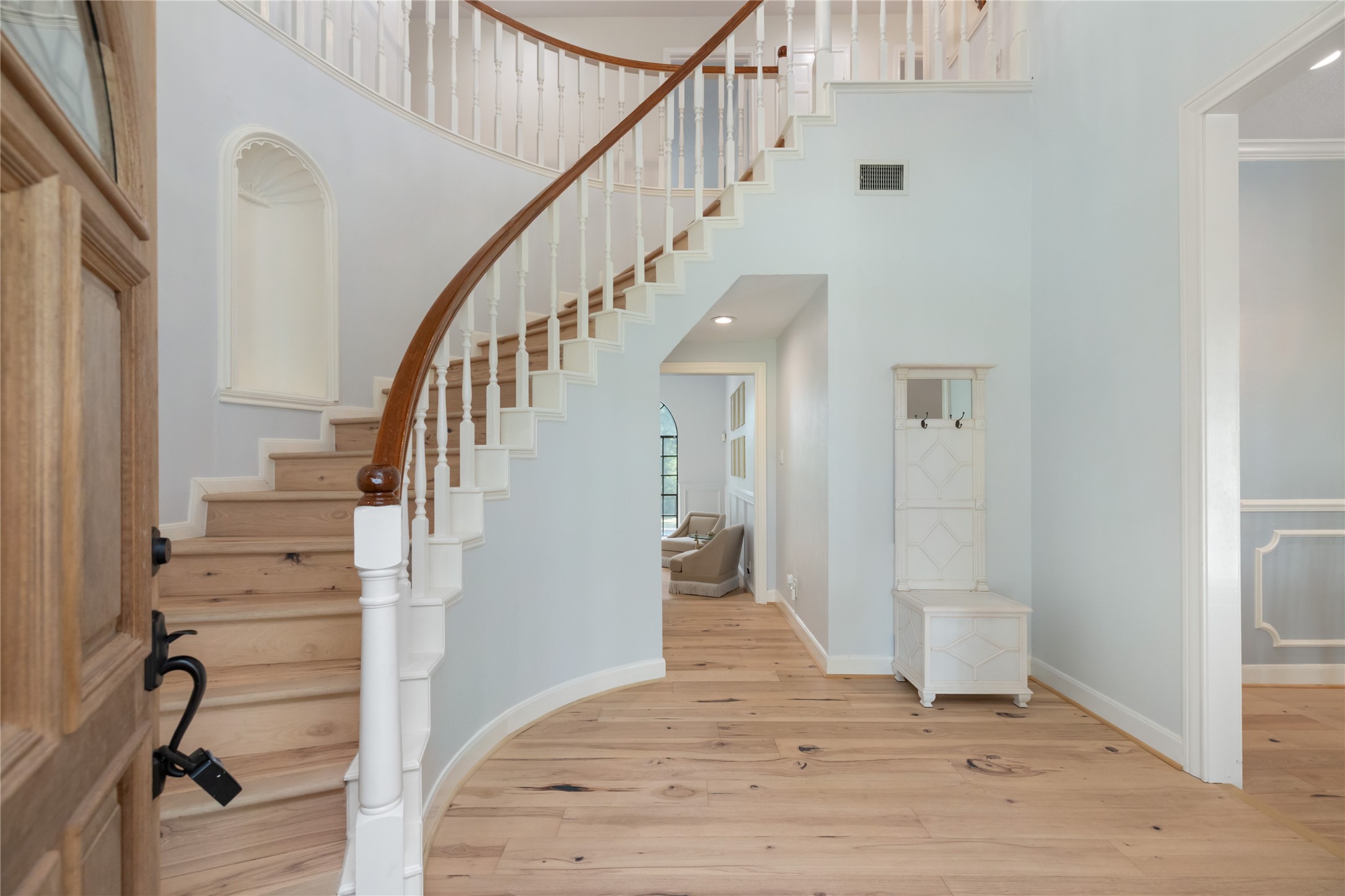 17003 Creeksouth Road Houston, TX 77068 - Photo 10 of 49 An unforgettable first impression—designer paint, engineered wood floors, and soaring ceilings set the tone, while the sweeping curved staircase adds a dramatic, elegant touch just beyond the front door.