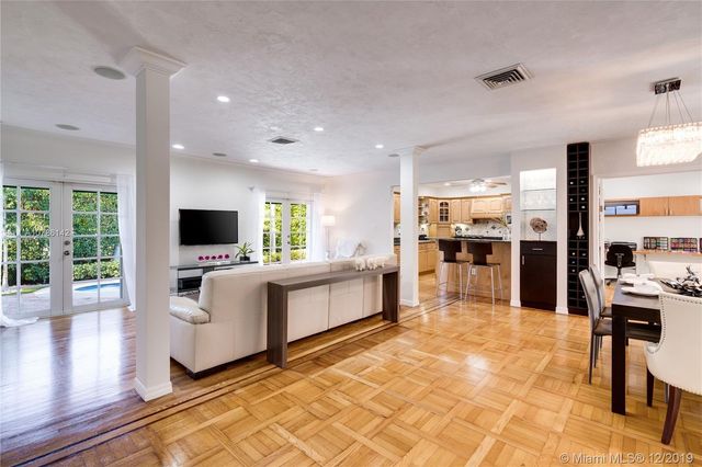 a large white kitchen with a large window and furniture