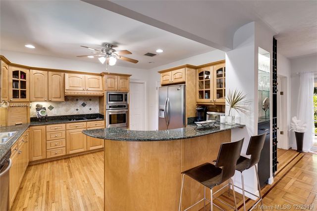 a large kitchen with kitchen island a large counter top space appliances and cabinets