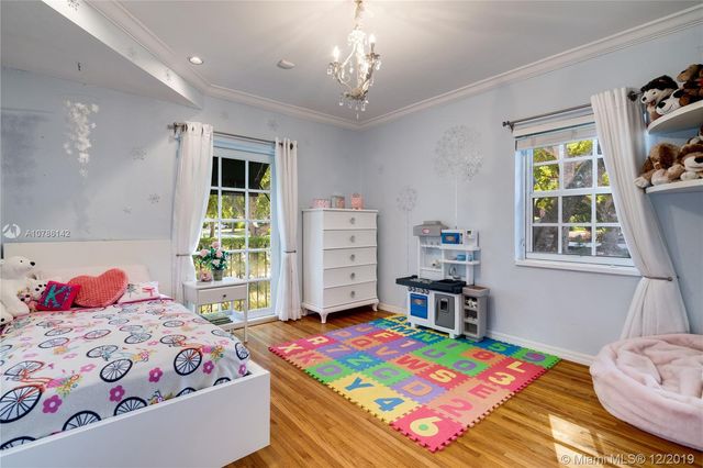 a bedroom with a bed a dresser and a window