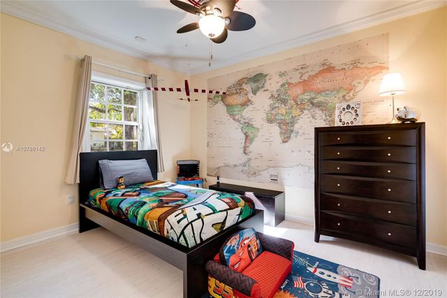 a bedroom with a bed a chandelier and a dresser