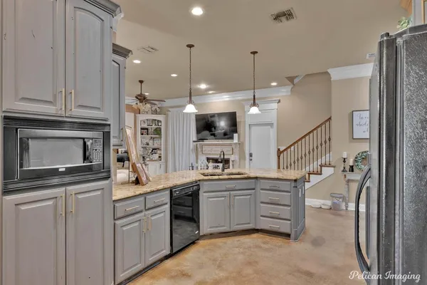a kitchen with stainless steel appliances granite countertop a refrigerator stove and sink with cabinets