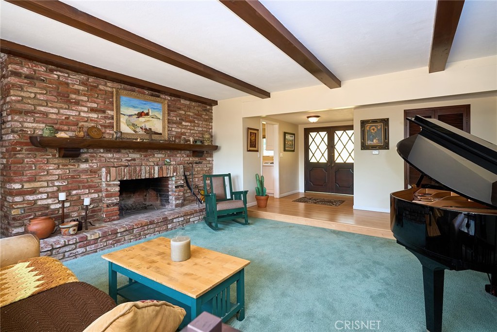 10370 Topeka Drive Porter Ranch, CA 91326 - Photo 7 of 33 a living room with furniture a rug and a fireplace