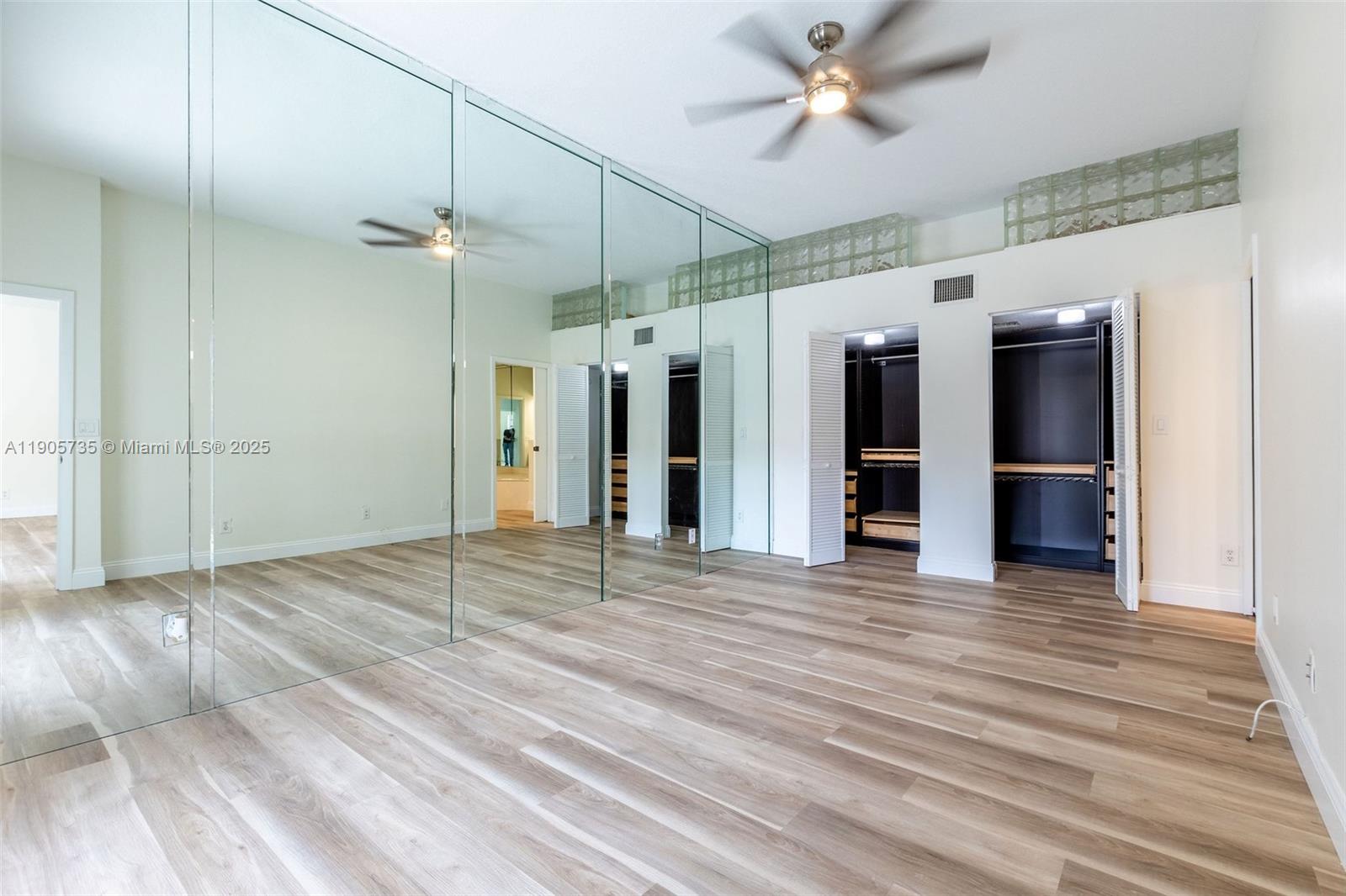 15865 Southwest 6th Place, Unit 201 Pembroke Pines, FL 33027 - Photo 19 of 80 an empty room with wooden floor ceiling fan and windows