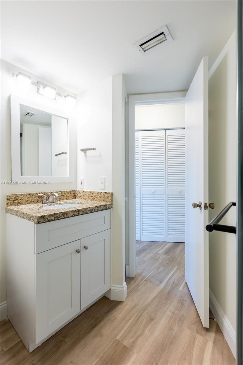 15865 Southwest 6th Place, Unit 201 Pembroke Pines, FL 33027 - Photo 39 of 80 a bathroom with a granite countertop sink and a mirror