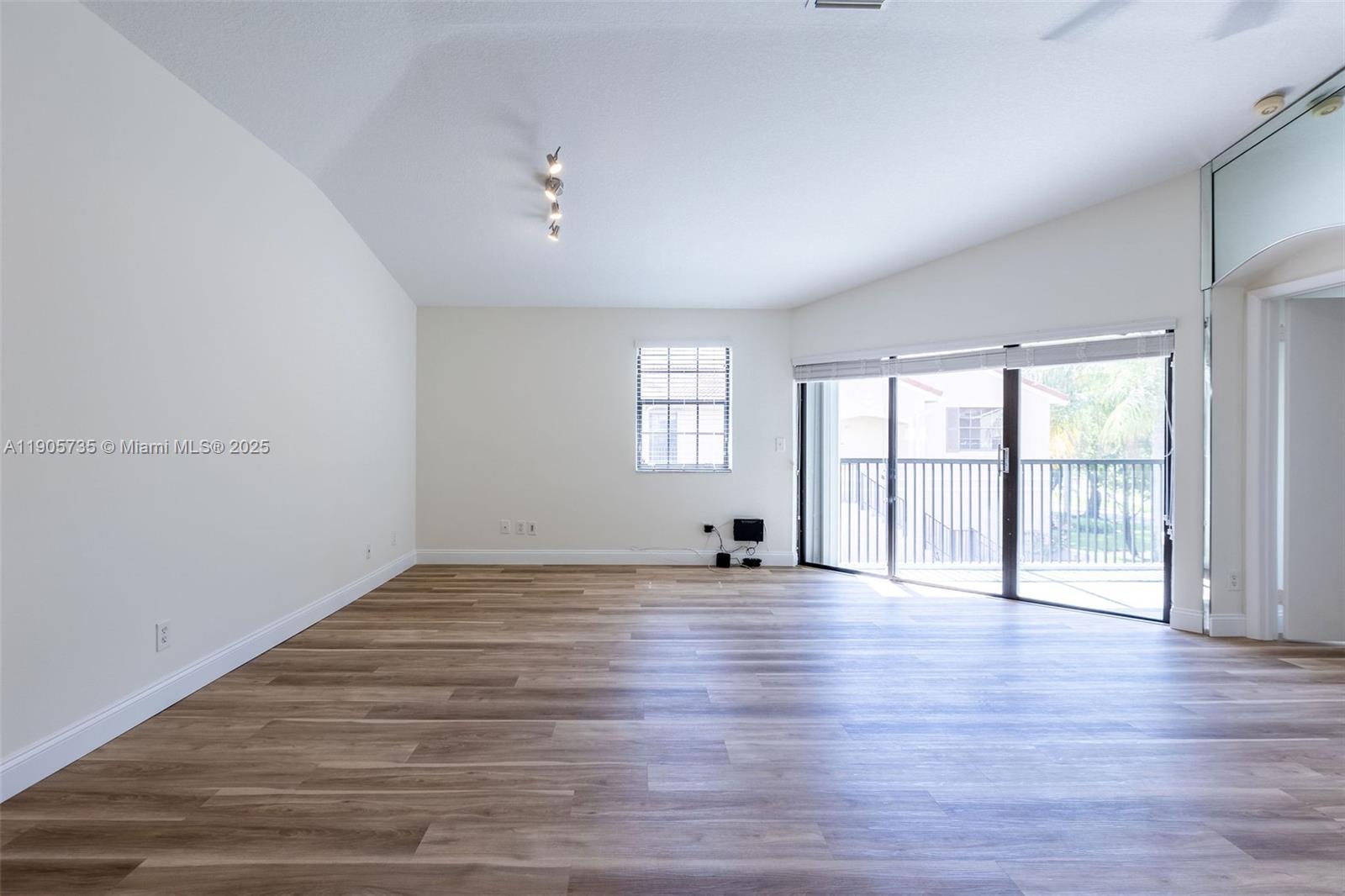 15865 Southwest 6th Place, Unit 201 Pembroke Pines, FL 33027 - Photo 58 of 80 an empty room with wooden floor and windows