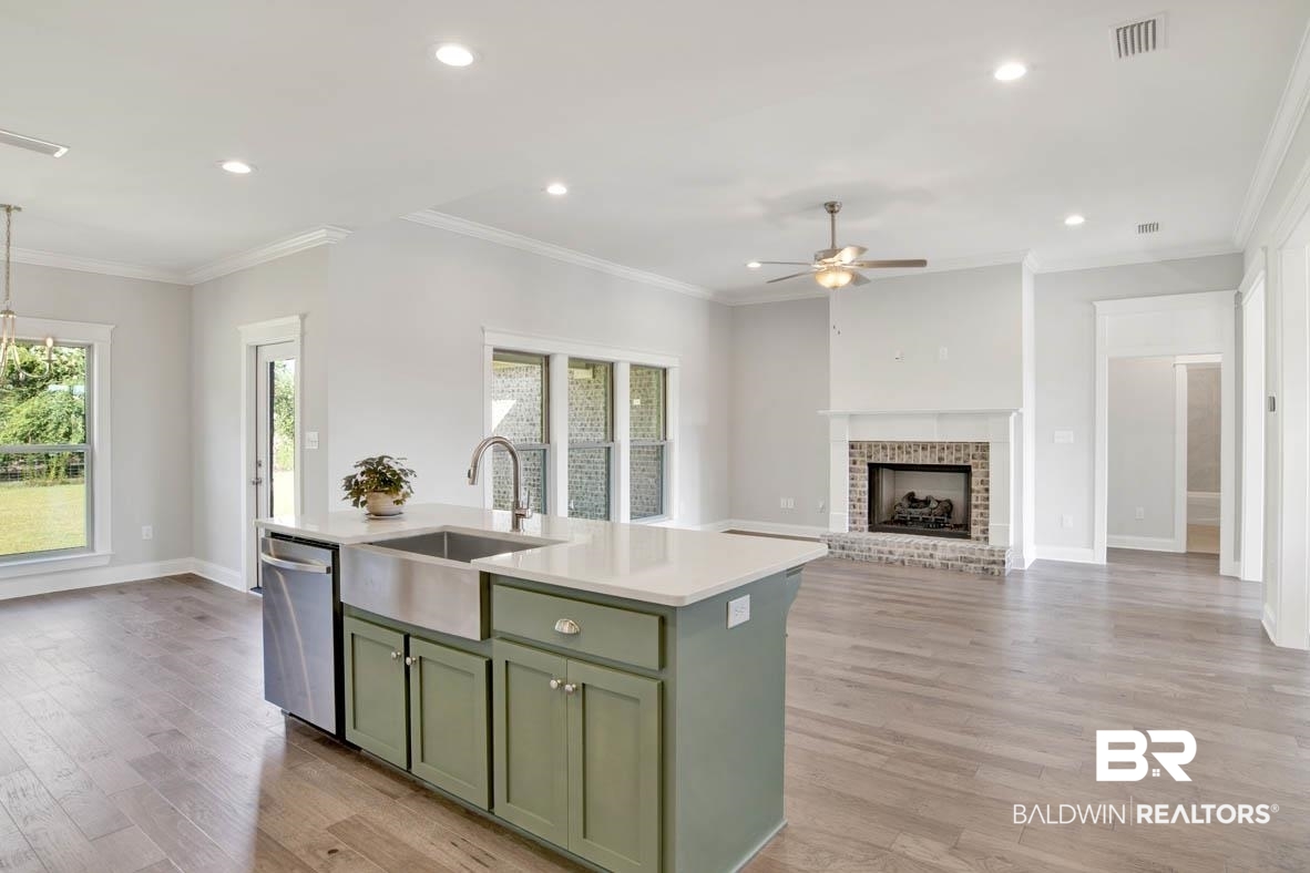 393 Garrison Boulevard Fairhope, AL 36532 - Photo 16 of 40 Kitchen with dishwasher, a brick fireplace, light hardwood / wood-style floors, sink, and ceiling fan