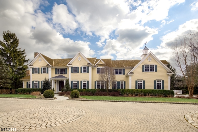 a view of white house with a big yard and large trees
