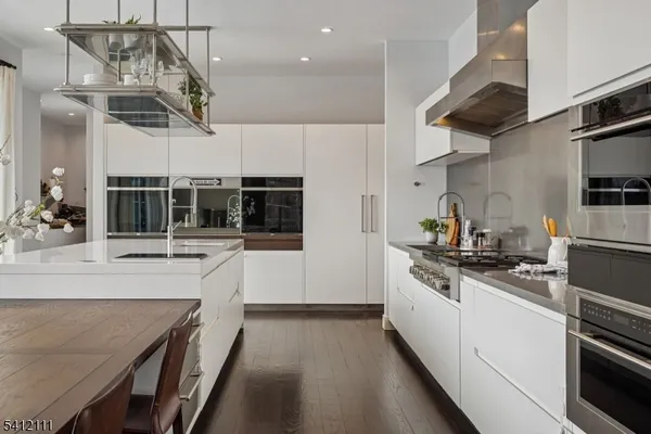 a kitchen with stainless steel appliances granite countertop a sink a stove and cabinets