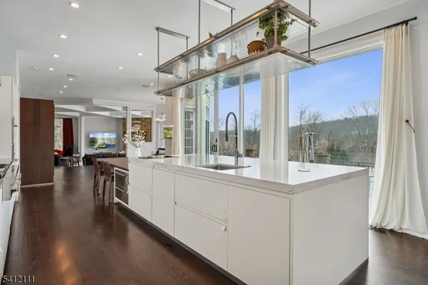 a open kitchen with stainless steel appliances granite countertop a refrigerator a sink and a stove with wooden floor