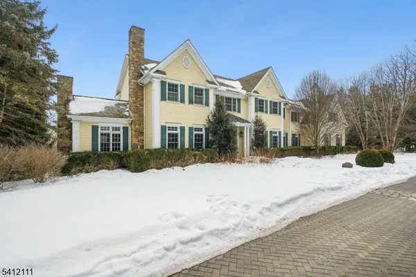 a front view of a house with a yard covered in snow