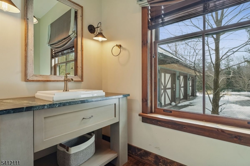 89 Mosle Road Peapack-Gladstone, NJ 07931 - Photo 42 of 45 a bathroom with a granite countertop sink a mirror and a shower