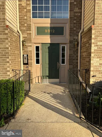 a view of a brick house with a small yard and wooden floor and fence