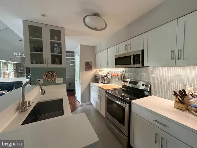 a kitchen with a sink a stove and cabinets