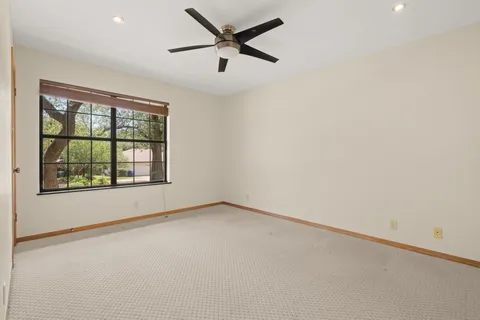 an empty room with a window and a ceiling fan