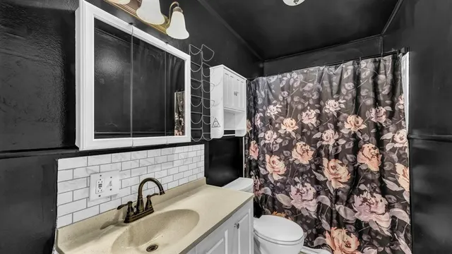 a bathroom with a sink toilet and shower