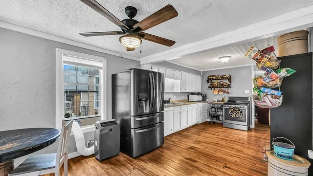 a kitchen with a refrigerator a stove cabinets and wooden floor