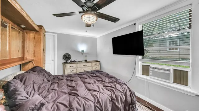 a bedroom with a bed and a flat tv screen on dresser