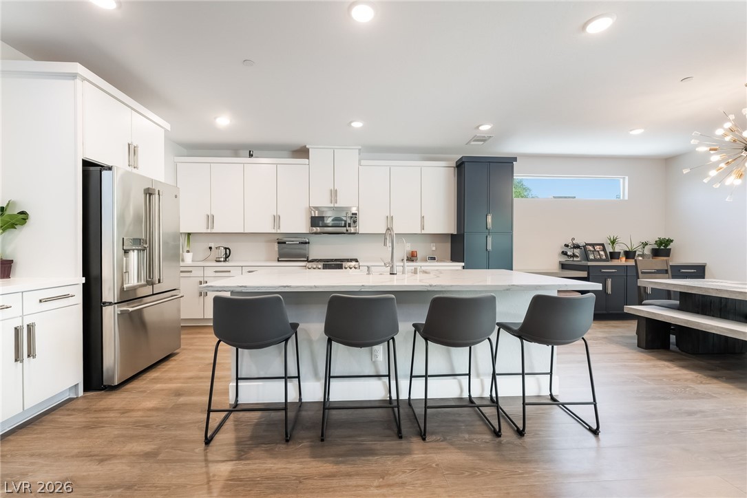2166 Trivero Street Henderson, NV 89044 - Photo 9 of 61 Culinary adventures await in this modern kitchen, featuring a spacious island with seating for four.