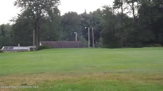 a view of a swimming pool with a patio and a yard