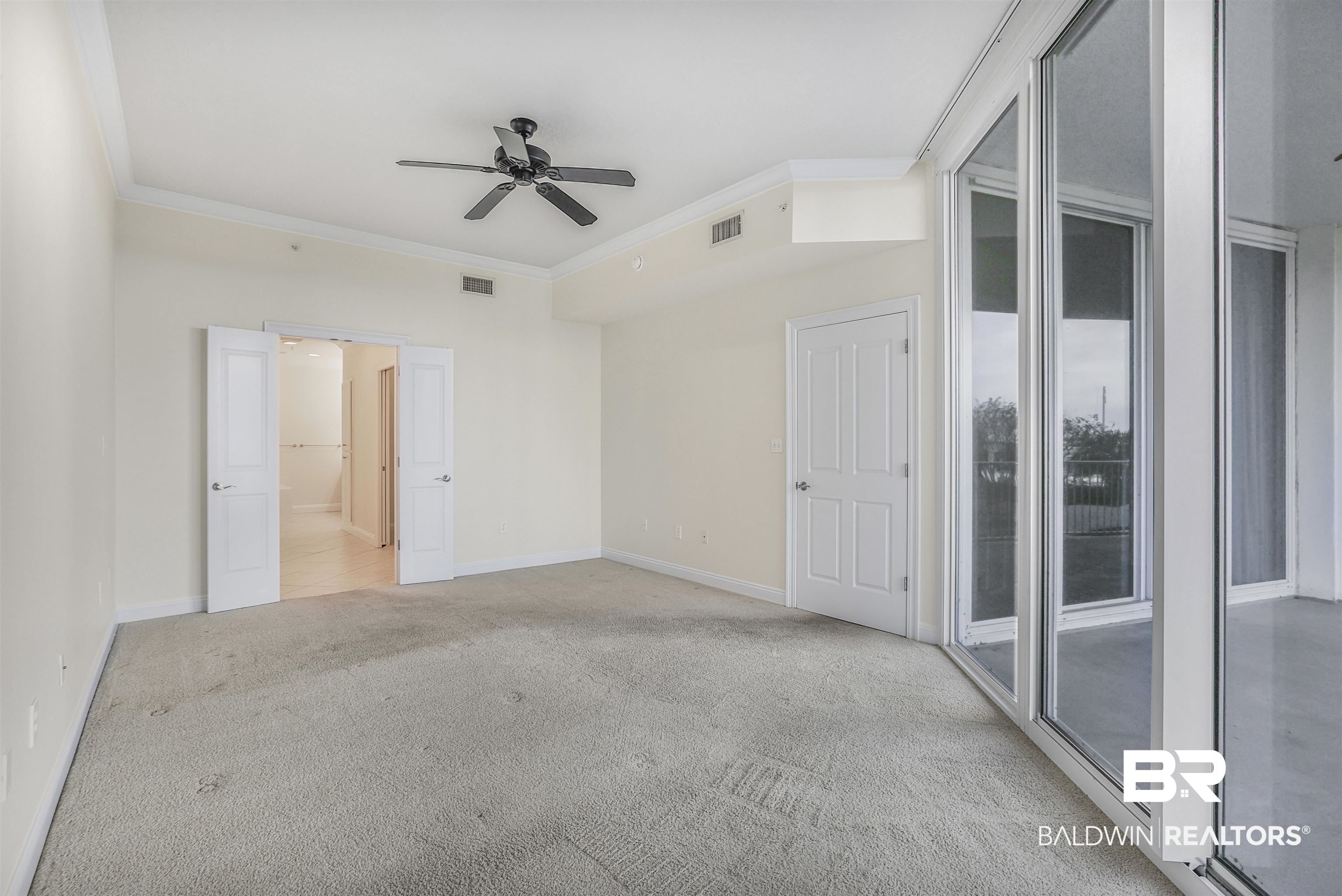 28250 Canal Road, Unit 106 Orange Beach, AL 36561 - Photo 11 of 50 Unfurnished bedroom featuring ornamental molding, a ceiling fan, and light carpet