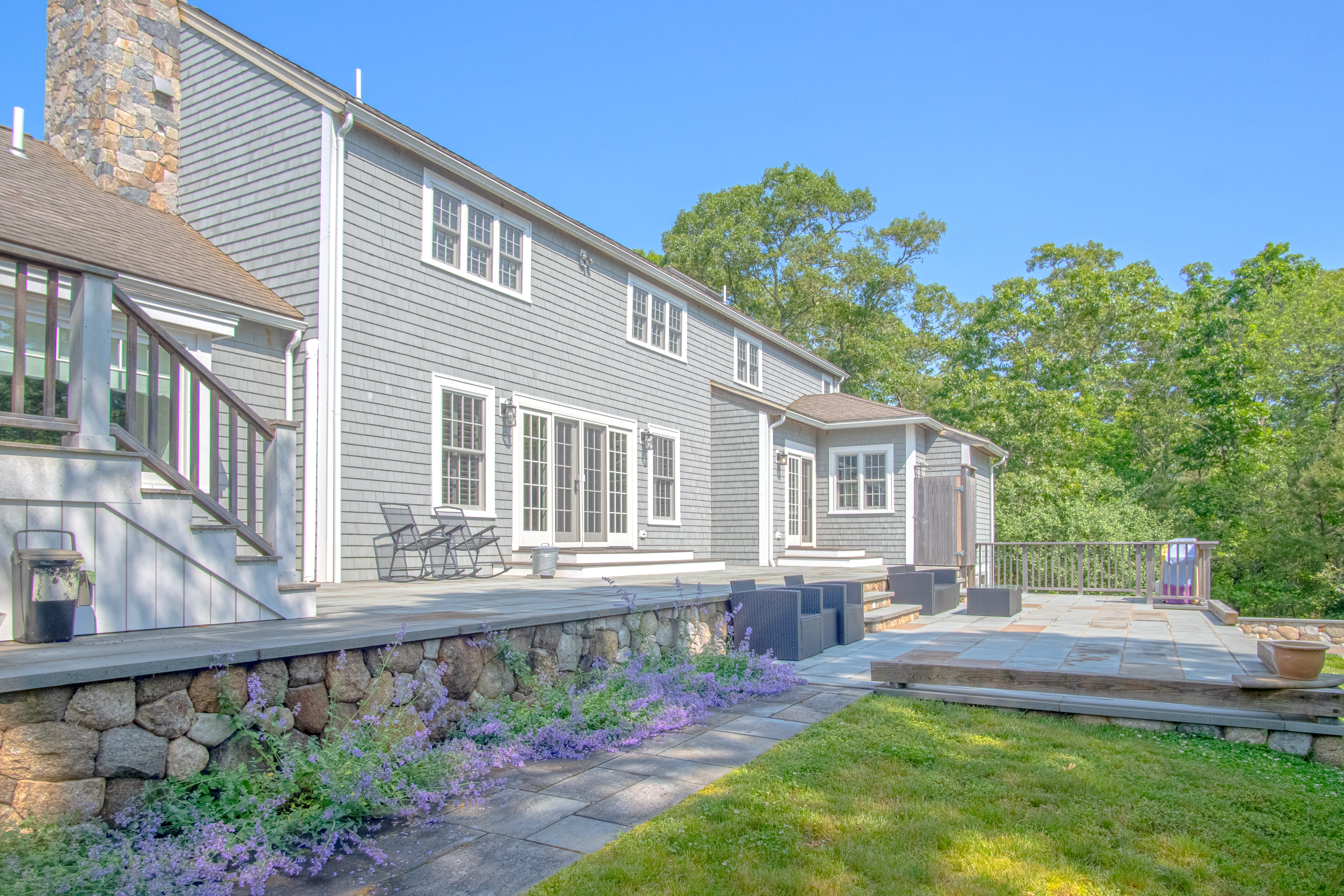 63 Bayes Hill Road Oak Bluffs, MA 02557 - Photo 4 of 60 a front view of a house with a yard table and chairs
