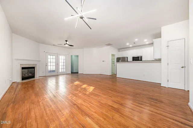 a view of empty room with wooden floor and fireplace