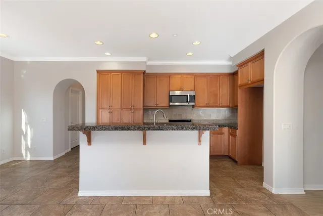 a kitchen with stainless steel appliances a refrigerator sink stove microwave and cabinets