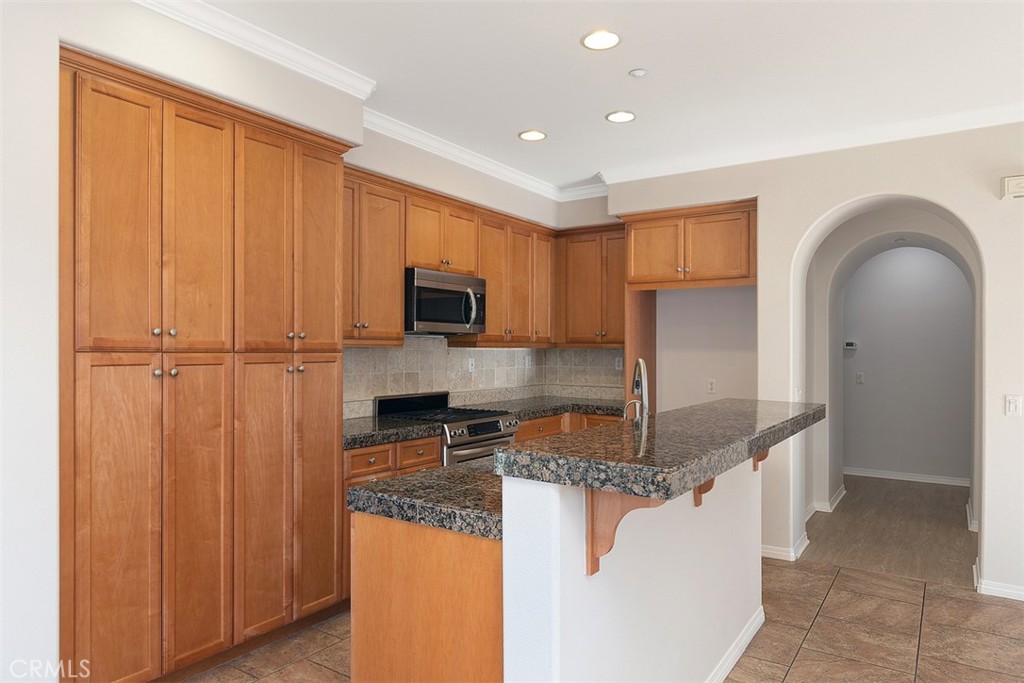 96 Talisman, Unit 23 Irvine, CA 92620 - Photo 13 of 43 a kitchen with stainless steel appliances granite countertop a stove a sink and a refrigerator