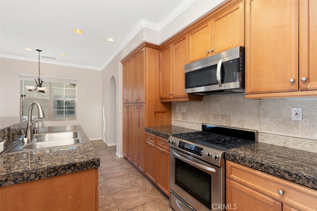 96 Talisman, Unit 23 Irvine, CA 92620 - Photo 15 of 43 a kitchen with stainless steel appliances granite countertop a sink stove and microwave
