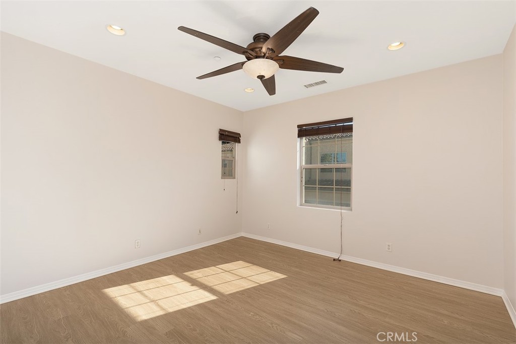 96 Talisman, Unit 23 Irvine, CA 92620 - Photo 22 of 43 an empty room with wooden floor and ceiling fan