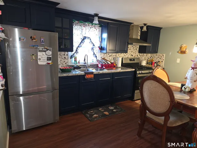 a kitchen with granite countertop a refrigerator stove and sink