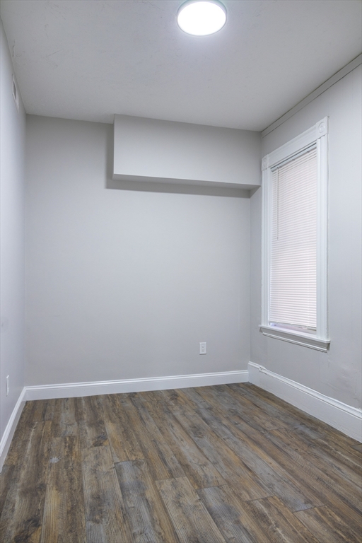 626 East 6th Street, Unit 3 Boston, MA 02127 - Photo 4 of 5 a view of an empty room with wooden floor and a window