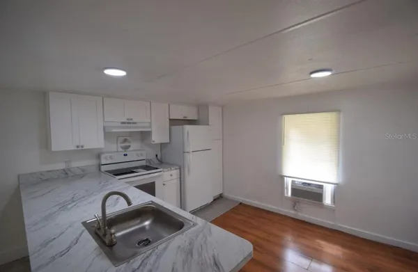 a kitchen with stainless steel appliances granite countertop a stove a sink dishwasher and a refrigerator