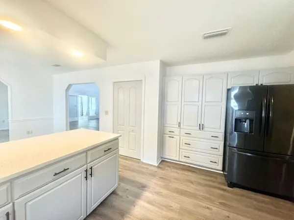 a kitchen with granite countertop a refrigerator and a stove top oven