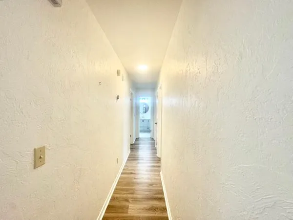 a view of a hallway with wooden floor