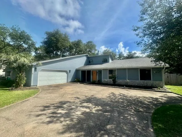 a front view of a house with yard and trees