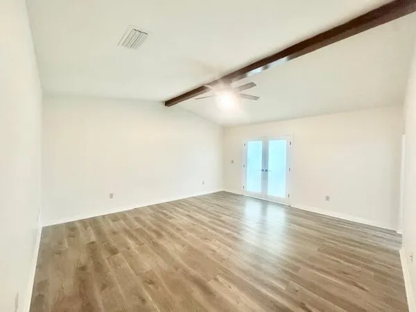 a view of empty room with wooden floor