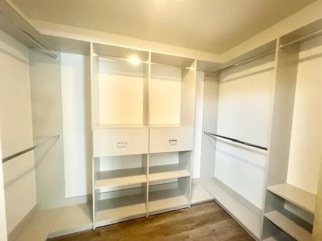 a view of walk in closet with empty racks