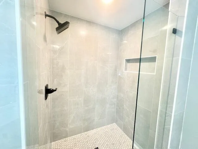 a bathroom with a shower and a glass door