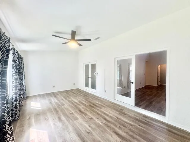 a view of a livingroom with wooden floor and a ceiling fan