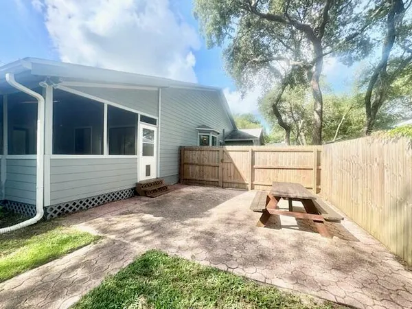 a white house that has tree in front of it