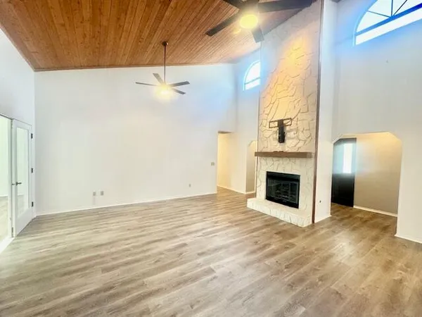 an empty room with windows and fireplace