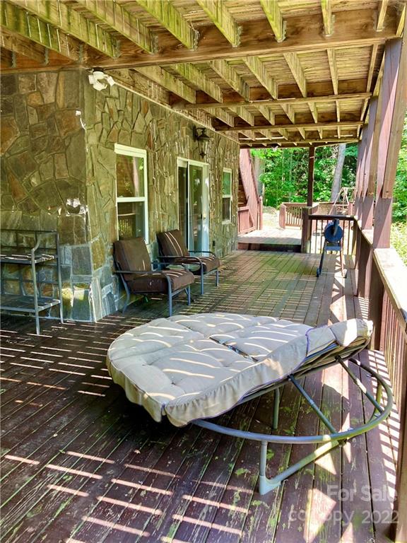 160 Flying Hawk Road Waynesville, NC 28786 - Photo 15 of 45 a view of a patio with table and chairs with wooden floor and plants