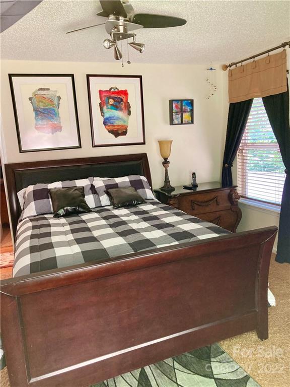 160 Flying Hawk Road Waynesville, NC 28786 - Photo 29 of 45 a bedroom with a bed and a painting on the wall